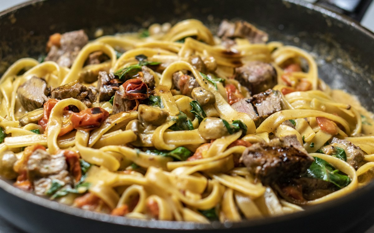 In der Gusseisenpfanne gebratene Schupfnudeln mit Sauerkraut und knusprigem Speck